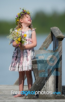 Little Girl With Flowers Looking Up Stock Photo