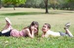 Children Lie Down On Grass Stock Photo