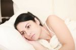 Worried Woman Lying In Bed Stock Photo