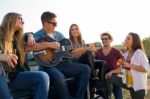Portrait Of Group Of Friends Playing Guitar And Drinking Beer Stock Photo