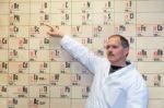 Chemistry Teacher Pointing At Periodic Table Stock Photo