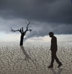 Man Walking Alone In Arid Land Stock Photo