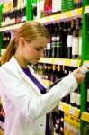 Woman Choosing Bottle Of Wine Stock Photo