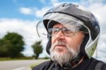 Portrait Of Elderly Motorcyclist Wearing A Jacket And Glasses Wi Stock Photo