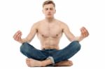 Shirtless Young Man Doing Meditation Stock Photo