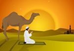 Man Praying And Camel With Sunset Background Stock Photo