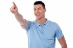 Casual Young Man Pointing Away Stock Photo