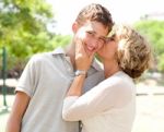 Image Of Portrait Of A Happy Senior Woman Kissing Grandson Stock Photo