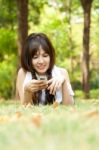 Young Woman Lying With Phone Stock Photo