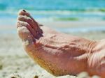 Foot In The Sand On The Beach Stock Photo