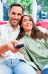 Happy Young Couple Watching Tv On Sofa Stock Photo