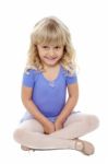 Adorable Kid Sitting With Crossed Legs On The Floor Stock Photo