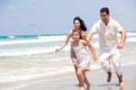 Family Running On The Beach Stock Photo