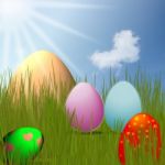 Colorful Easter Eggs Sitting On Grass Field With Blue Sky Background Stock Photo