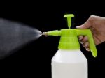 Fresh Water Spray From Bottle By Hand Isolated On Black Stock Photo