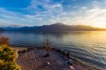 Sunset Over Mountains With A Lake And Shoreline Stock Photo