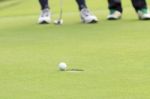 Golf Ball On The Edge Of Hole Stock Photo