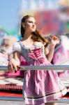 Attractive Young Woman At German Funfair Oktoberfest With Traditional Dirndl Dress Stock Photo