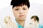 Upset Boy With Pictures Of Parents Stock Photo