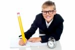 Schoolboy Writing With Timepiece Stock Photo