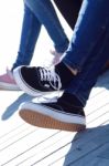 Legs Of Young Girl In Jeans And Sneakers Stock Photo