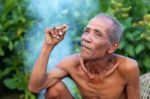 Older Men Sit Smoking In Countryside Stock Photo