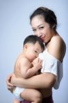Young Asian Mother Holding Her Baby And Breast Feeding Baby Stock Photo
