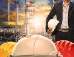 Engineering Man With White Safety Helmet Standing In Front Of Oil Refinery Building Structure In Heavy Petrochemical Industry Stock Photo