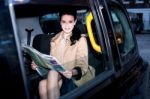 Female Passenger Reading Newspaper Inside Taxi Stock Photo