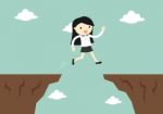 Business Concept, Business Woman Jump Through The Gap To Another Cliff Stock Photo