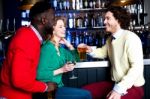 Group Of Three Friends In A Bar Drinking Beer Stock Photo