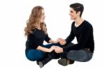 Young Loving Couple On Floor Holding Hands Stock Photo