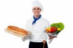 Smiling Chef Holding Bread And Vegatables Stock Photo