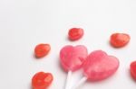 Pink Valentine's Day Heart Shape Lollipop With Small Red Candy In Cute Pattern On Empty White Paper Background. Love Concept.  Minimalism Colorful Hipster Style Stock Photo