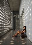 Asian Girl Sitting On Corridor Floor Stock Photo