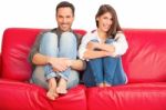 Happy Young Couple Relaxing On Sofa Stock Photo