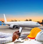 Hand Touching On Computer Tablet On Working Table Against Air Plane Parking In Airport Runway Use For Freight,cargo Logistic And Air Transportation Theme Stock Photo