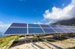 Row Of Solar Collectors On Mountain With Blue Sky Stock Photo