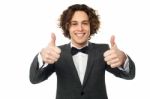 Joyous Young Guy Gesturing Double Thumbs Up Stock Photo
