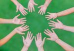 Arms Of Children Together In Circle On Green Background Stock Photo