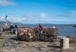 Fishermen Repairing Their Lobster Pots On The Harbour Wall At Ly Stock Photo