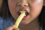Asian Girl Eating French Fries Stock Photo