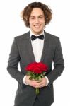 Groom In Tuxedo Posing With A Bouquet Stock Photo