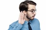 Corporate Man Listening With Hand On Ear Stock Photo
