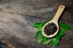 Spoons With Dried Leaves Tea And Green Leaves Tea Stock Photo