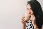 Woman Drinking Hot Latte Coffee At Cafe Stock Photo