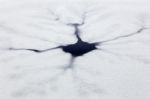 Cracks And Hole In Ice On Pond Stock Photo