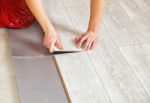 Handyman's Hands Laying Down Laminate Flooring Boards Stock Photo