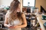 Brunette In Kitchen With Mobile Phone Stock Photo
