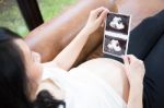 Pregnant Woman Looking At Ultrasound Picture Stock Photo